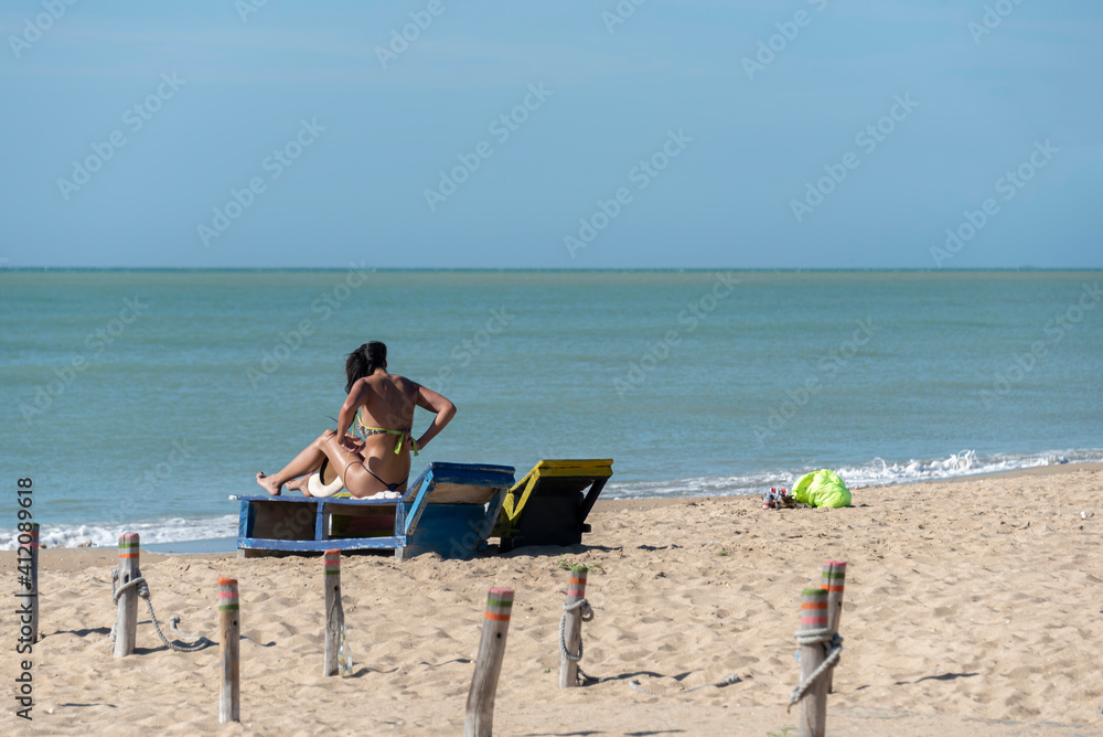 Girl tanning under a bright sun on a beach
