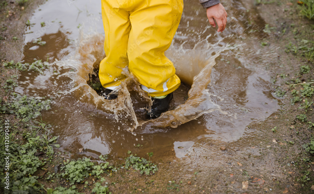 Young kid with three years old jumping on puddles Young kid with three years old jumping on puddles