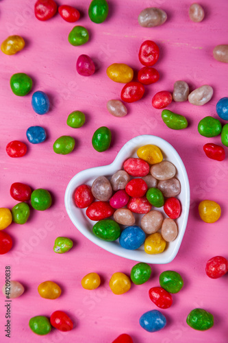 Multicolored candies in a plate in the shape of a heart