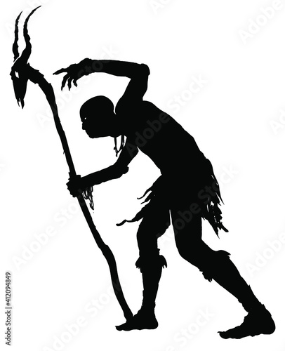 Black silhouette of a sinister stooped old shaman with a creepy staff with a goat's skull in his hand, he makes an intimidating voodoo gesture with his crooked fingers 2d illustration