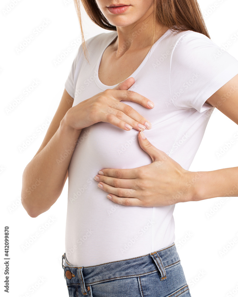 Woman hand checking lumps on her breast for signs of breast cancer on gray background. Healthcare concept. Woman hand checking lumps on her breast for signs of breast cancer on gray background. Healthcare concept.