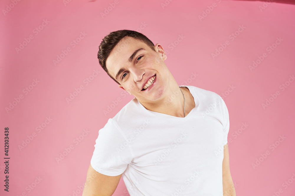 A man in a white t-shirt gestures with his hands emotions pink background studio cropped view A man in a white t-shirt gestures with his hands emotions pink background studio cropped view