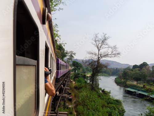 Thai express train running through the green forest near River Kwai.