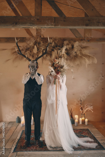 para młoda w maskach elegancja, romantyzm maska zwierzęcia i bukier kwiatów zasłonięte twarze pary młodej, rystykalny ślub, ślub boho 