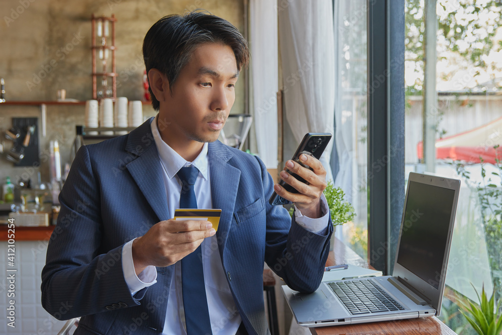 Front Right Asian Businessman in Suit Using Smartphone for Online Payment in Coffee Shop Scene. Asian Businessman Work from Anywhere with Technology Front Right Asian Businessman in Suit Using Smartphone for Online Payment in Coffee Shop Scene. Asian Businessman Work from Anywhere with Technology