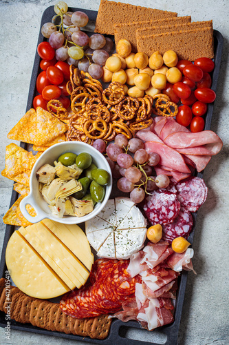 Charcuterie and cheese platter.  Appetizers tray with assorted meat, cheese, fruits, olives and crackers.