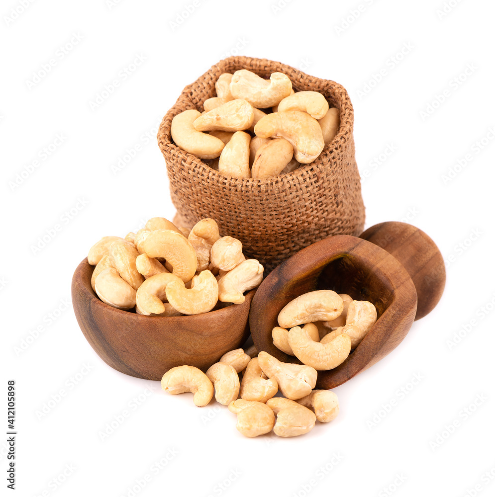 Cashew nuts in bag and wooden bowl, isolated on white background. Roasted cashew nuts.
