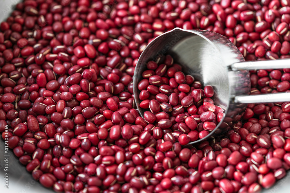 Close up red beans in measuring cup, Measuring cup scooping organic red beans in aluminum bowl. Close up red beans in measuring cup, Measuring cup scooping organic red beans in aluminum bowl.