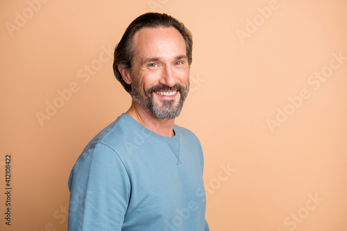 Photo portrait of happy man wearing blue sweatshirt smiling isolated on pastel beige color background
