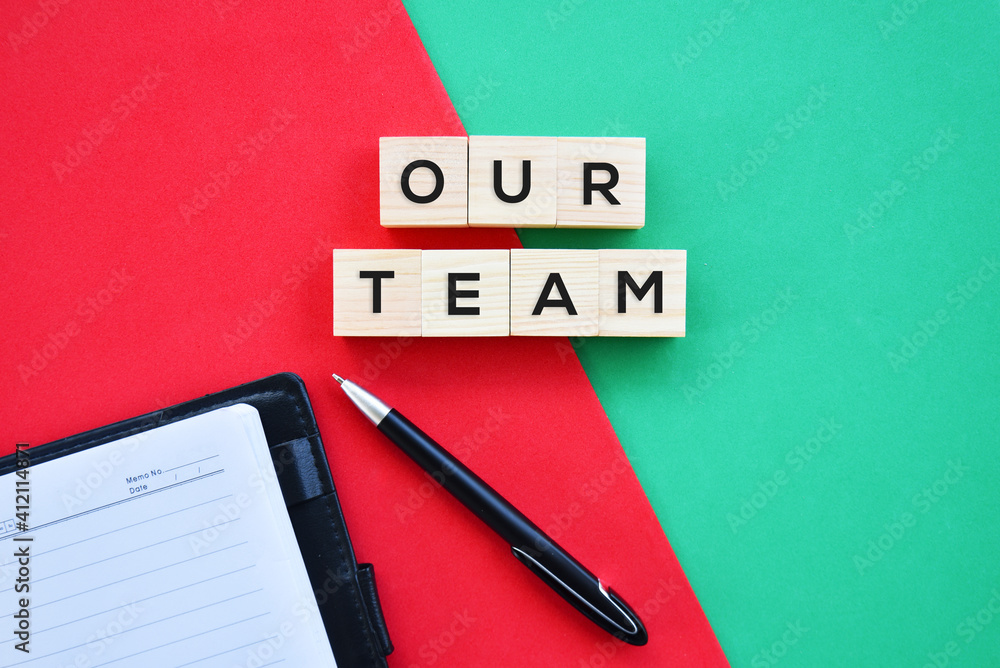 'Our Team' word on wood block with red and green background flat lay concept. 'Our Team' word on wood block with red and green background flat lay concept.