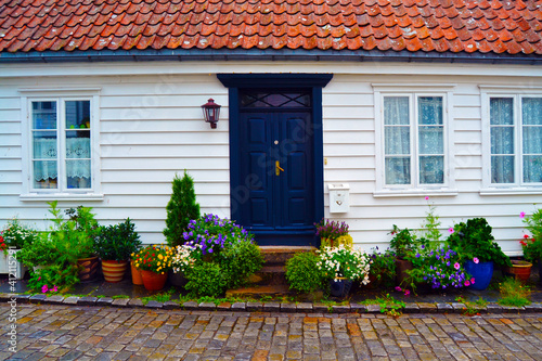 Facade of a white wooden house in the historic district Gamle Stavanger (Old Stavanger), Norway. Summer time in Stavanger.