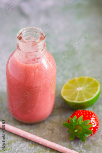 Strawberry smoothie in bottle on metal background