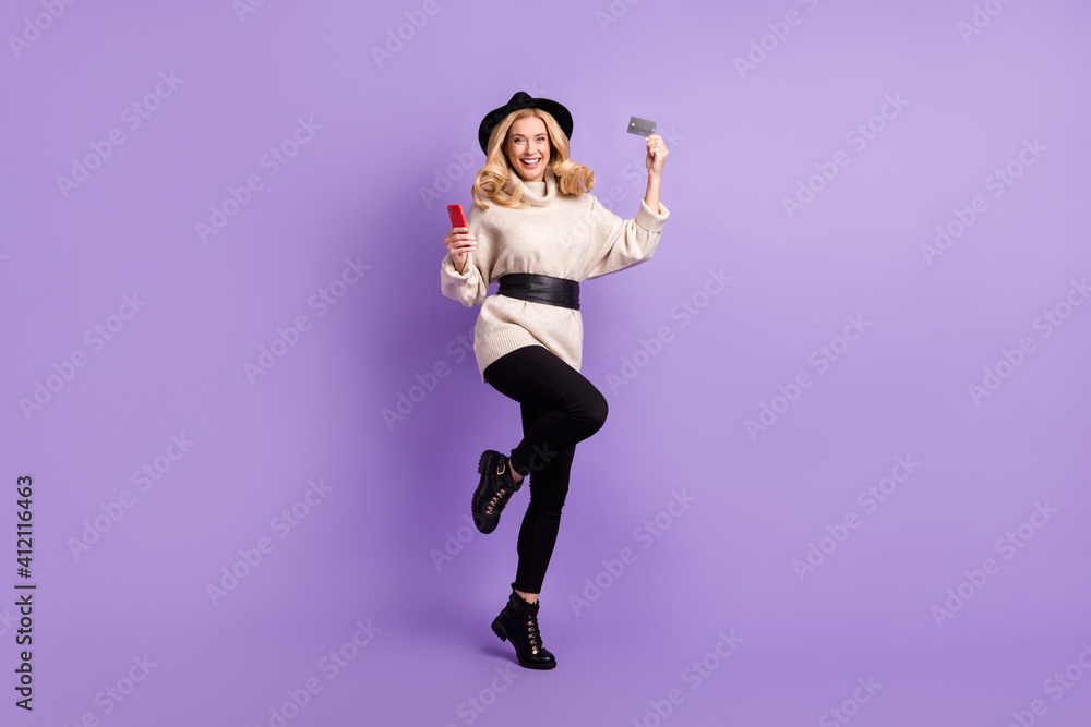 Full size photo of blonde haired woman wear white jumper hold phone credit card isolated on violet color background