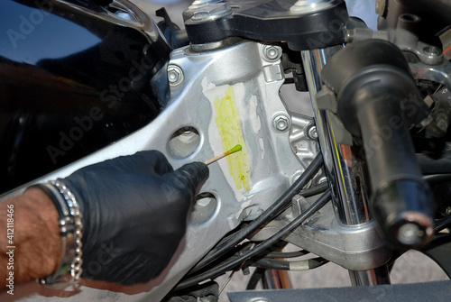 Scientific police with a swab and acid try to discover the hidden serial number of a motorcycle