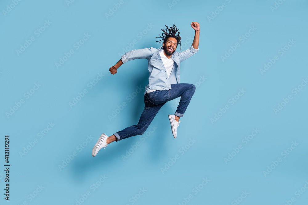Full length profile portrait of carefree dark skin guy rush speed toothy smile isolated on blue color background