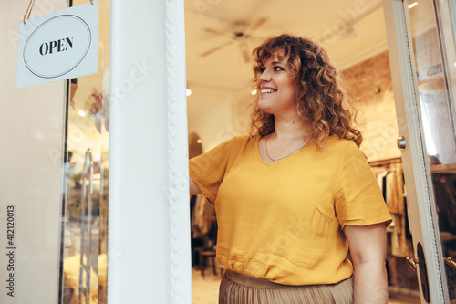Fashion boutique owner putting OPEN sign on door