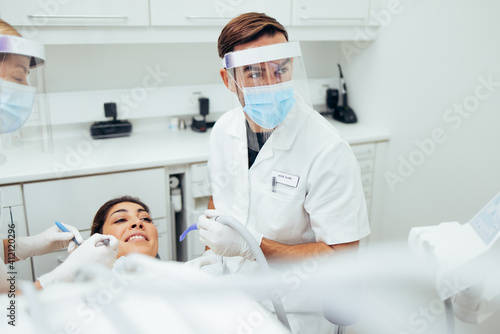 Dentist treating a female patient at dental clinic