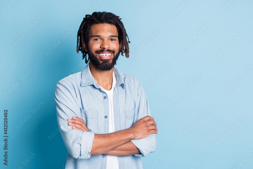 Portrait of attractive content cheerful guy wearing jeans shirt folded arms copy space isolated over bright blue color background Portrait of attractive content cheerful guy wearing jeans shirt folded arms copy space isolated over bright blue color background
