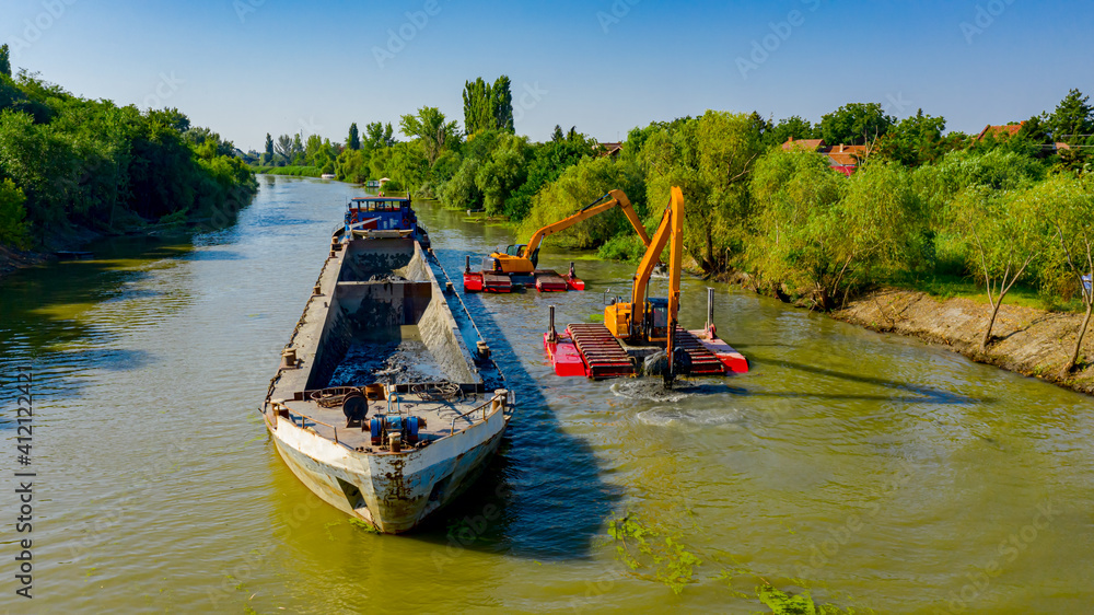 Aerial view of river, canal is being dredged by excavators