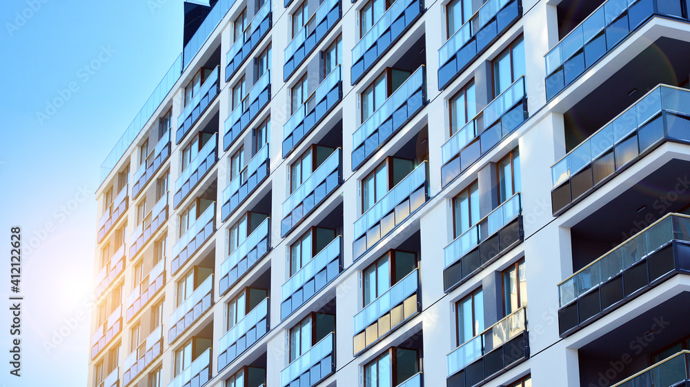 Modern apartment buildings on a sunny day with a blue sky. Facade of a modern apartment building.Glass surface with sunlight. Modern apartment buildings on a sunny day with a blue sky. Facade of a modern apartment building.Glass surface with sunlight.