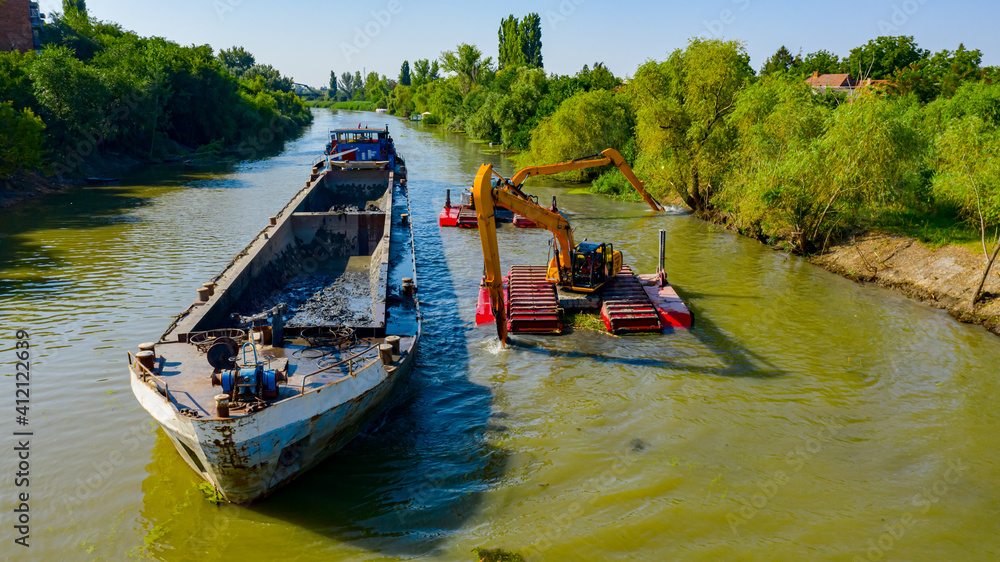 Naklejka premium Aerial view of river, canal is being dredged by excavators