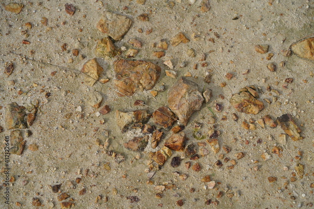 Small and big sulphur stones on the  hard sandy ground