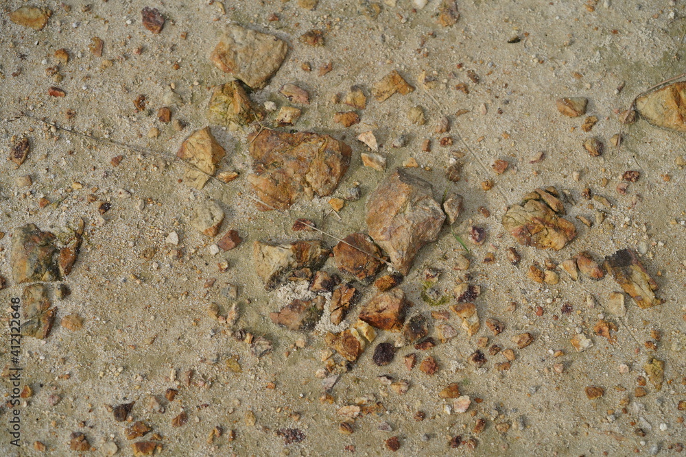 Small and big sulphur stones on the hard sandy ground Small and big sulphur stones on the hard sandy ground