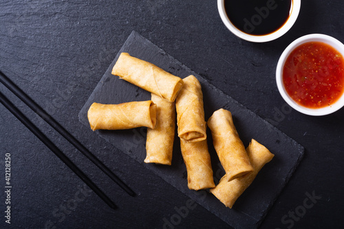 Fried spring rolls with vegetables on rustic background