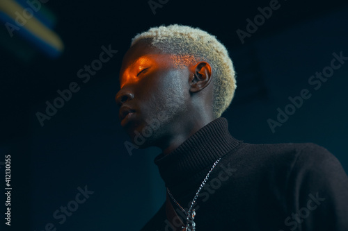 Valokuvatapetti portrait of a dark-skinned handsome guy with white hair dressed in a brown sweat