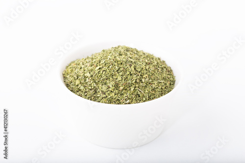 Dried peppermint in white bowl isolated on white background.