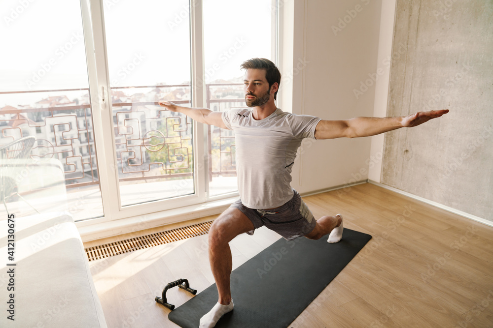 Focused man doing exercise while working out with push-up stops Focused man doing exercise while working out with push-up stops