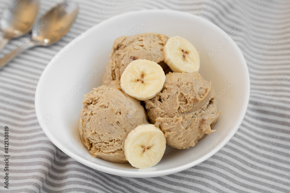 Homemade Peanut Butter Banana Ice Cream in a Bowl, side view. Close-up. Homemade Peanut Butter Banana Ice Cream in a Bowl, side view. Close-up.