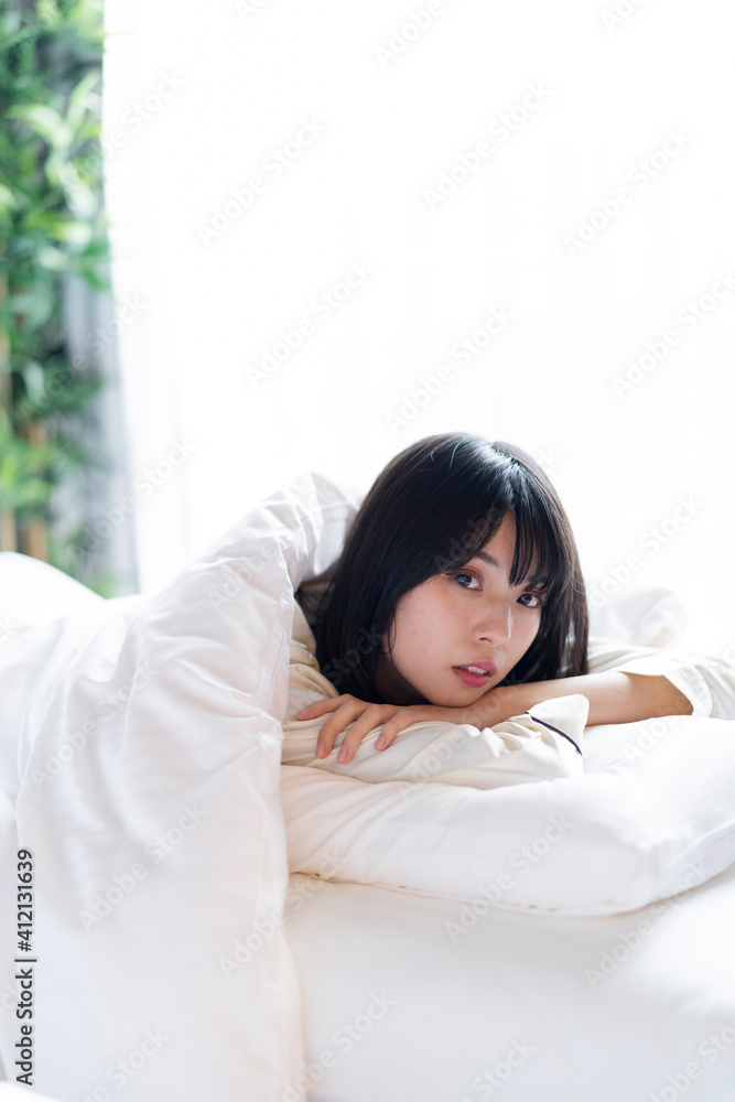 ベッドでリラックスする女性 ベッドでリラックスする女性