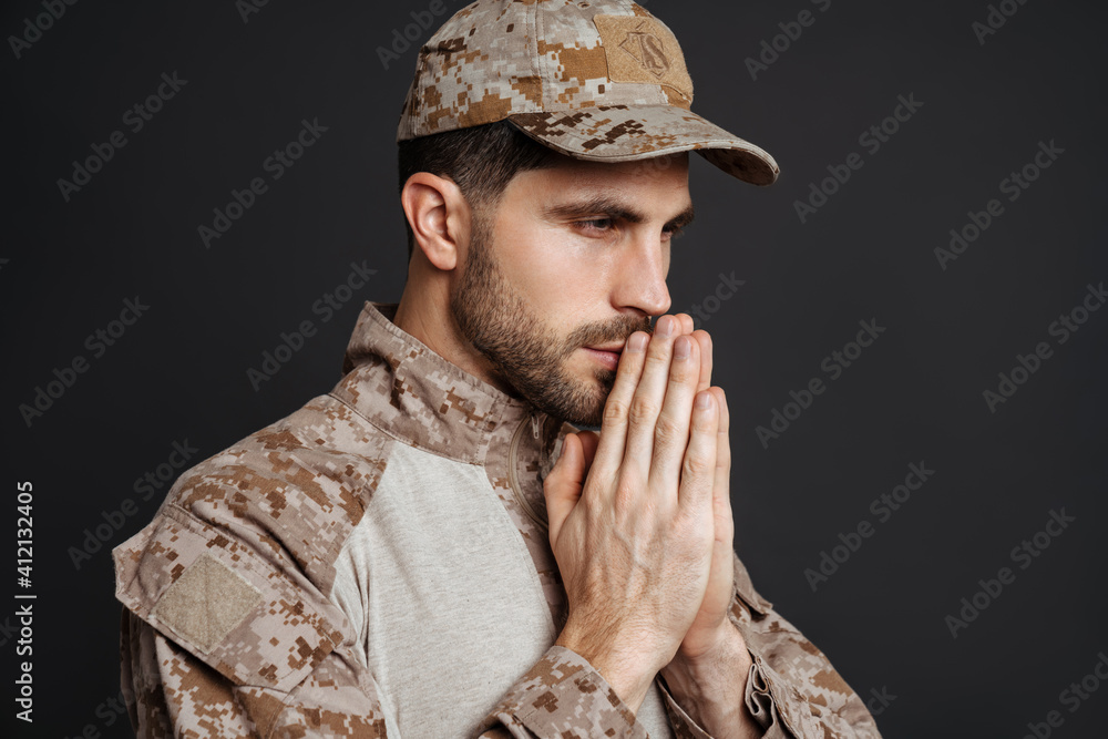 Focused masculine military man making praying gesture Focused masculine military man making praying gesture