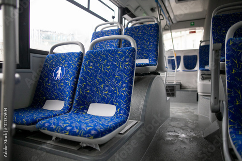 Empty bus interior. Blue seats without passengers. Public transport. Transportation of passengers by public transport. Ergonomic interior of the bus. Travel to other cities.