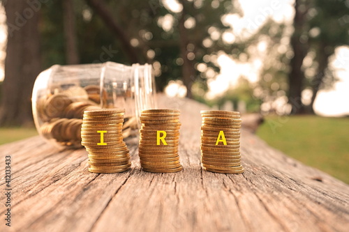 Fotografie Close up of stacking gold coins written IRA on nature background and natural lighting
