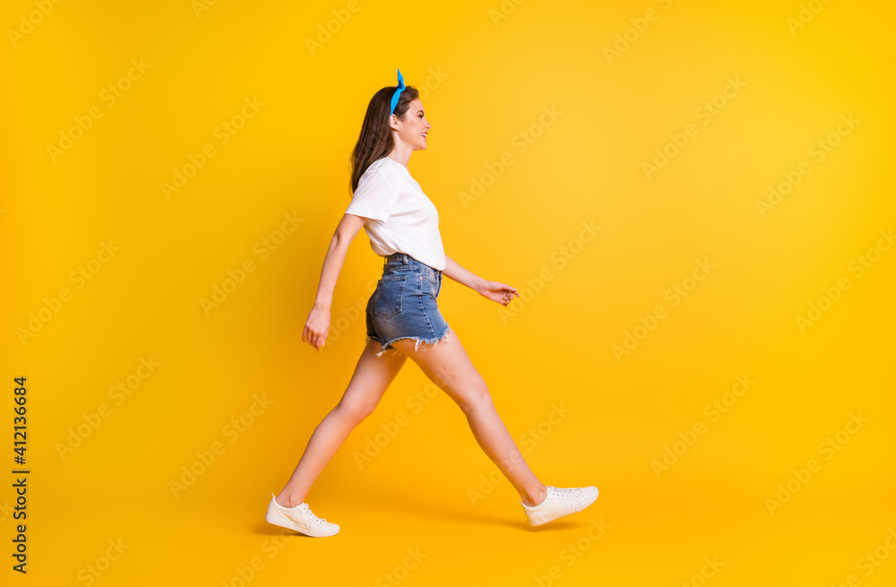 Full body profile side photo of fit young happy woman walk free time look copyspace isolated on yellow color background