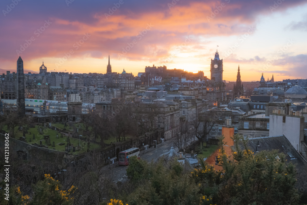 Classic sunset or sunrise cityscape view from Calton Hill taking in Princes Street, Edinburgh Castle and the Balmoral Clock Tower at Waverley Station in Edinburgh, Scotland.