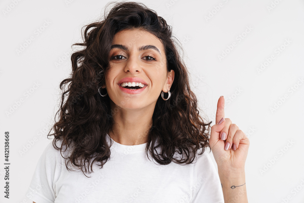 Happy beautiful brunette girl smiling and pointing finger upward Happy beautiful brunette girl smiling and pointing finger upward