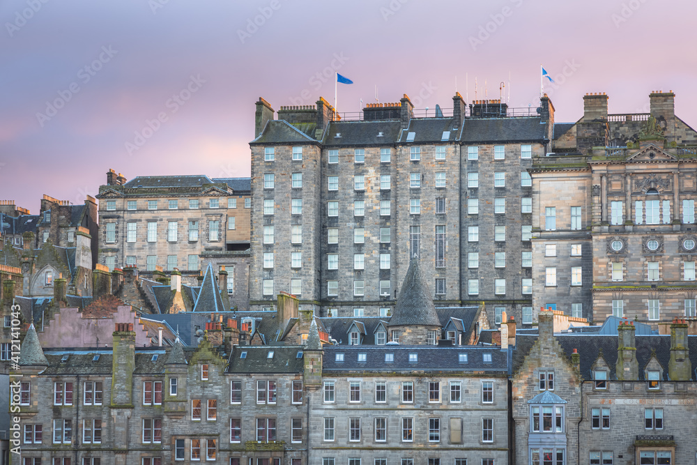 Fototapeta premium Sunset or sunrise cityscape view of the Edinburgh skyline and old town tenement buildings off the Royal Mile in the capital city of Scotland, UK.