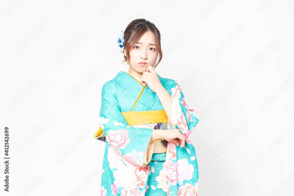 考え事をする振袖を着た女性