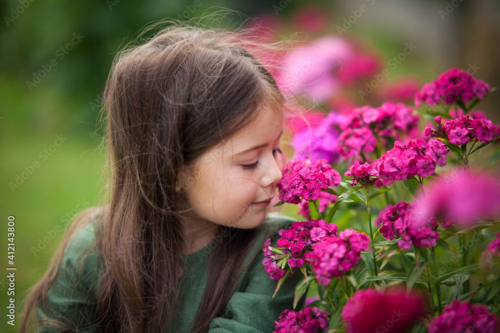 Cute girl in blossoming garden with pink flowers Cute girl in blossoming garden with pink flowers