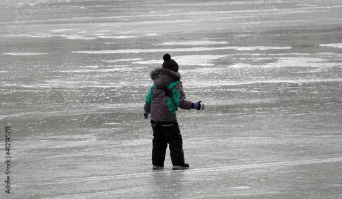 Children walk on the ice of a frozen lake
