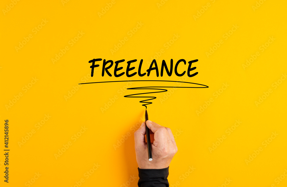 Male hand writing freelance on yellow background. Freelance job or working as a freelancer concept.. - obrazy, fototapety, plakaty 