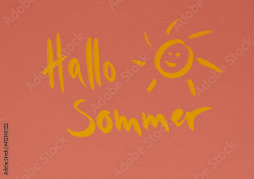 Gelber Schriftzug Hallo Sommer mit illustrierter lachender Sonne auf hellrosa Hintergrund