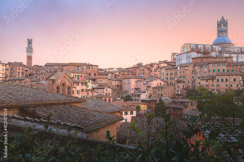 Scenic sunset or sunrise rooftop village view of Duomo di Siena and old town of Siena, Italy in the heart of Tuscany.