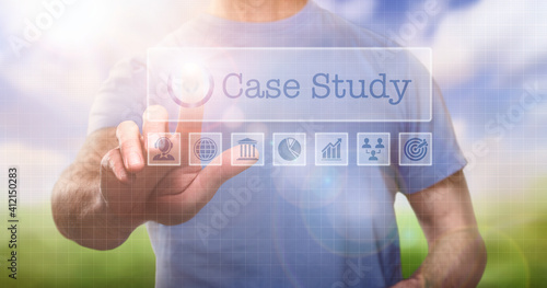 фотографія A man in a t-shirt outside selecting a Case Study concept word on a computerised