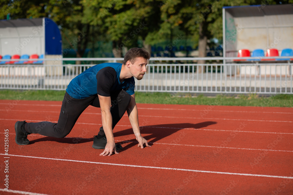 Obraz premium Sportive guy is ready to run at the stadium