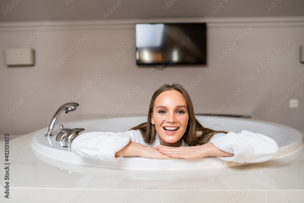Beautiful young slim woman in bathrobe lying in bathtub. Beautiful young slim woman in bathrobe lying in bathtub.