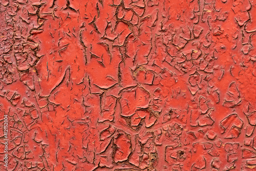 Abstract background, texture of cracked weathered paint in red color , close up. © Robert Adami